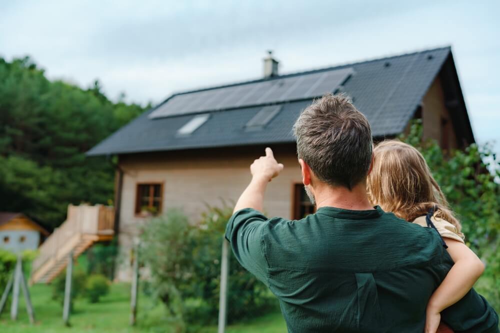 father pointing at solar panels with child