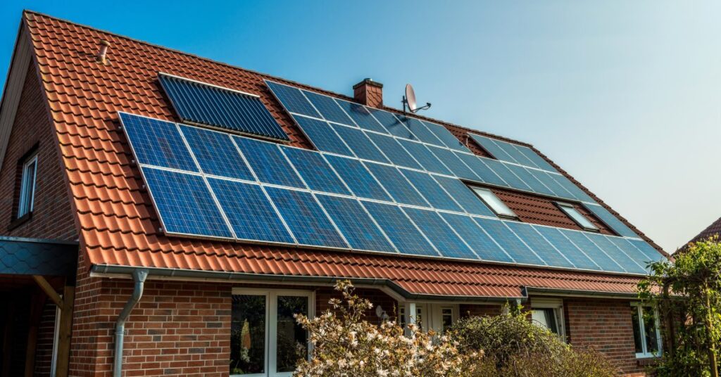 Will Solar Panel Installation Damage My Roof? 2 One-story home with a big, inclined roof covered in clay brown shingles with multiple solar panels installed.