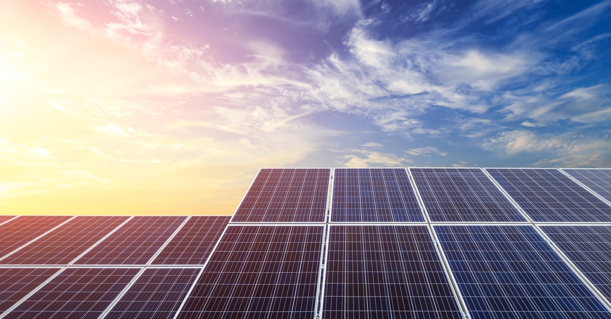 Top Questions To Ask Your Solar Power Solutions Company 1 Multiple rows of solar panels divided into two groups set at different levels. The sun is setting behind the panels.