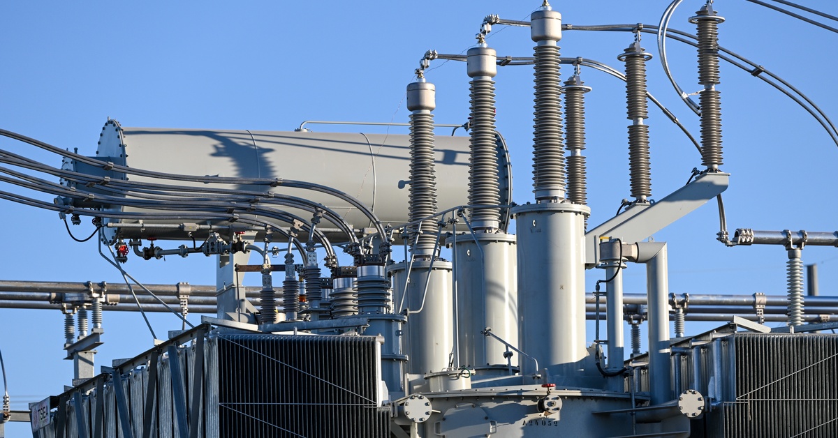 Learn 4 A close-up of the top part of an electrical grid with multiple connectors, cables, and coils, on a sunny day.