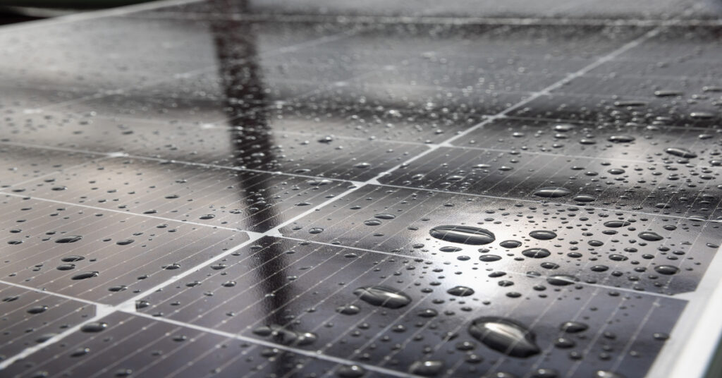 Solar Monitoring Systems Performance Data Access 2 A close-up of the electric cells with white divisions of a large solar panel covered in water drops of different sizes.