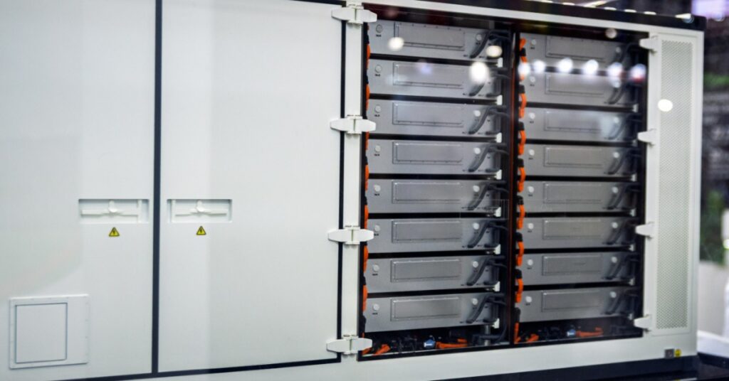 Tesla Megapack Cooling and Thermal Management 1 A close-up of a large box outdoors with multiple smaller interior boxes and cables attached on the right side.