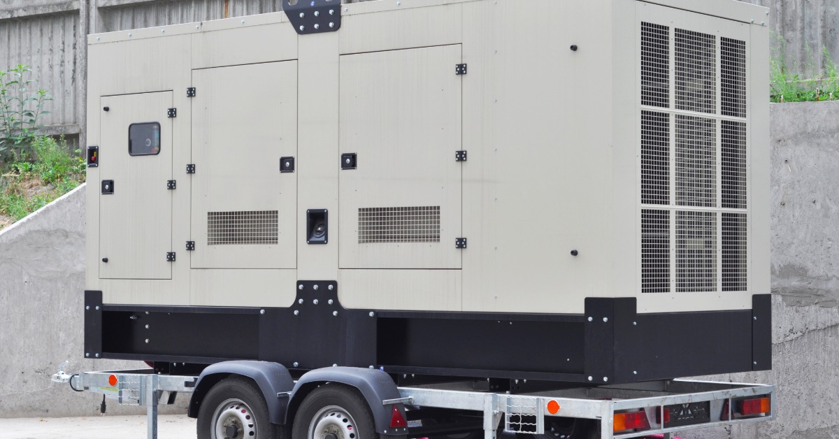 Tesla Megapack Cooling and Thermal Management 2 A large metal box with three smaller doors on the side, placed on a base with wheels on a concrete floor.
