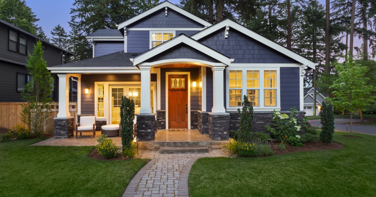 Off-Grid Capabilities of the Tesla Powerwall 2 A one-story home with lush grass in the front, a stone walkway, and multiple lights on in the interior and exterior.
