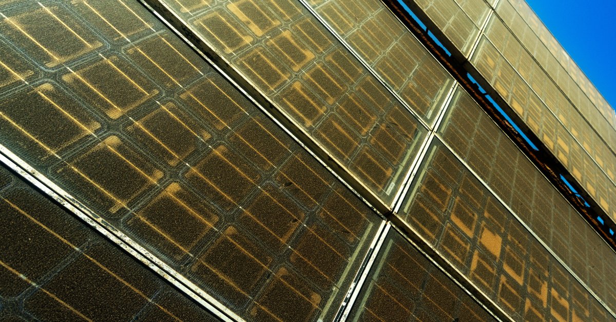 An Overview of Solar Panel Degradation Rates 1 A close-up of multiple old solar panels stacked on each other with a yellow finish, visible circuits, and dust.