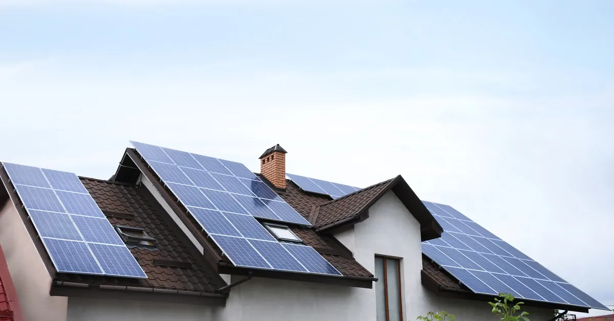 Learn 2 A close-up of the roof of a large two-story home with multiple rows of solar panels covering the entire surface.